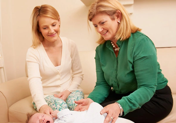 Kate providing postnatal support to a mother with her newborn